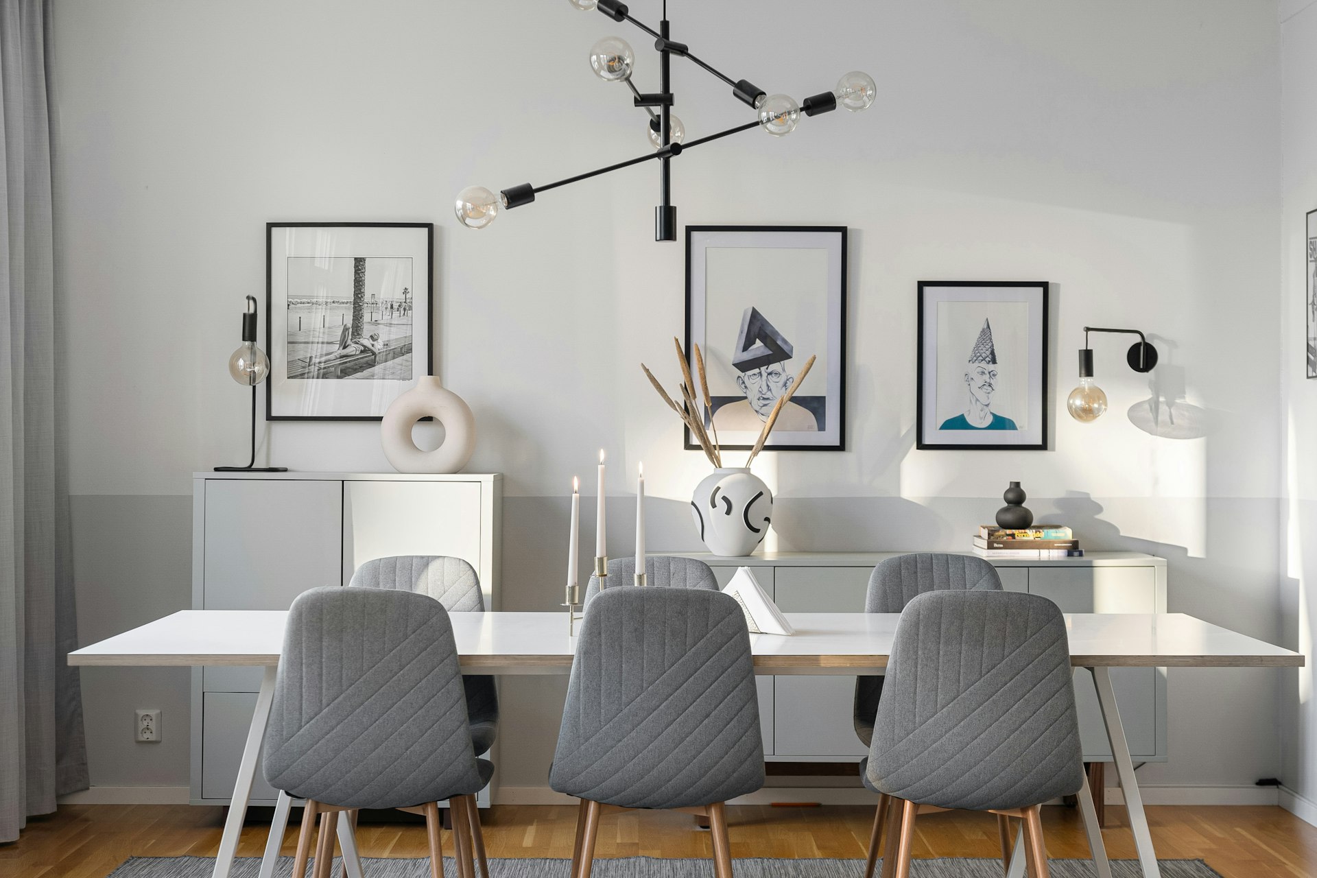 A dining room with a white table and gray chairs